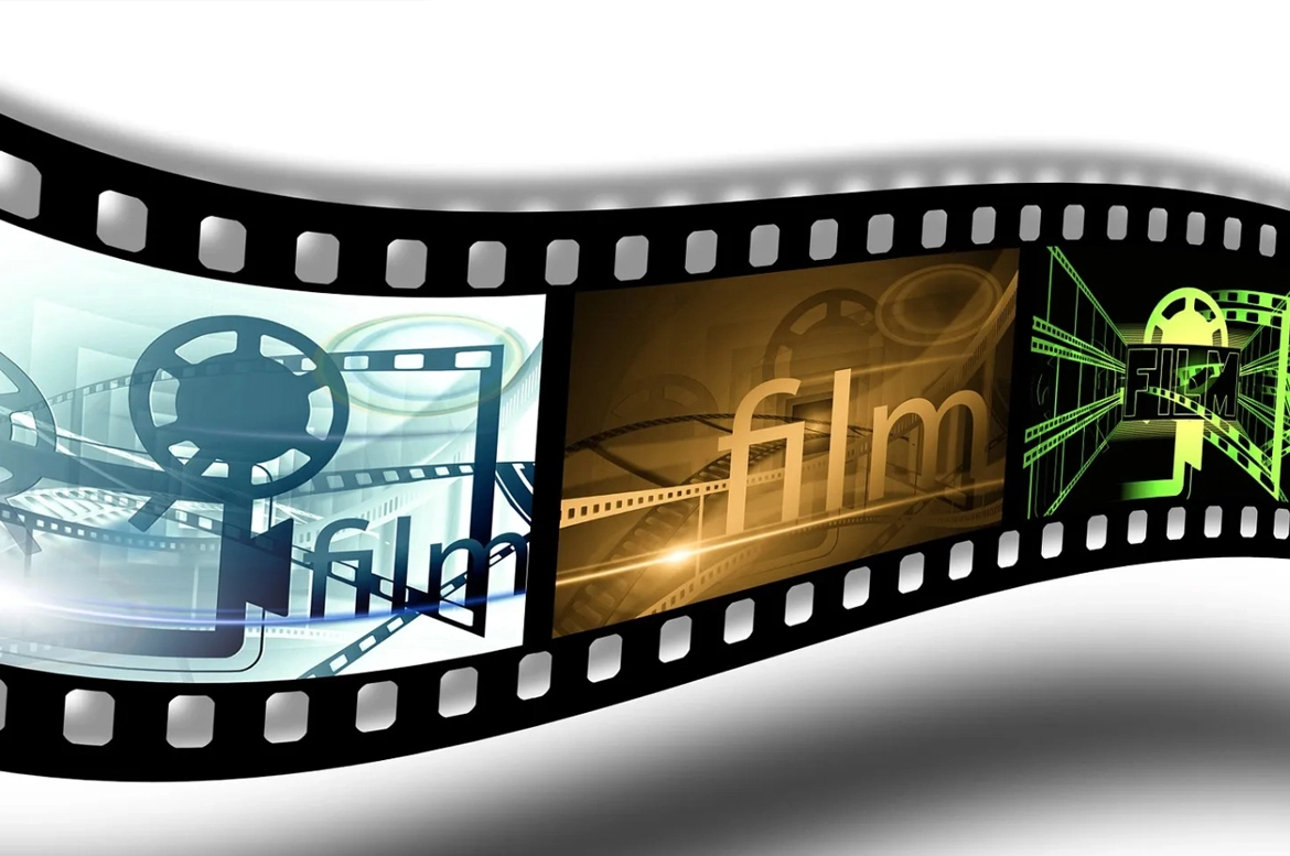 A digital film reel icon spins gracefully on a computer screen, representing the transition from traditional to digital filmmaking.